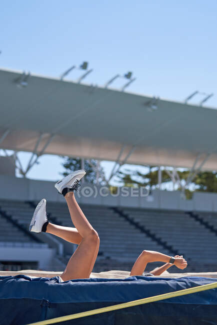 Atletismo feminino e atleta de campo caindo sobre o pólo de salto alto — Fotografia de Stock