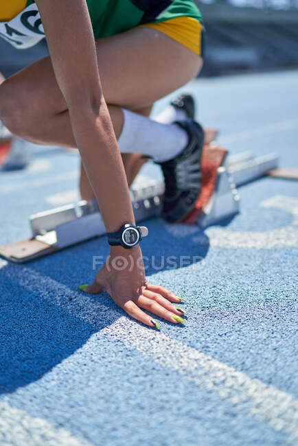 Chiudi pista femminile e atleta di campo al blocco di partenza — Foto stock