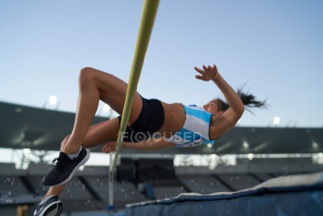 Athlète féminine d'athlétisme saut en hauteur par-dessus le pôle — Photo de stock