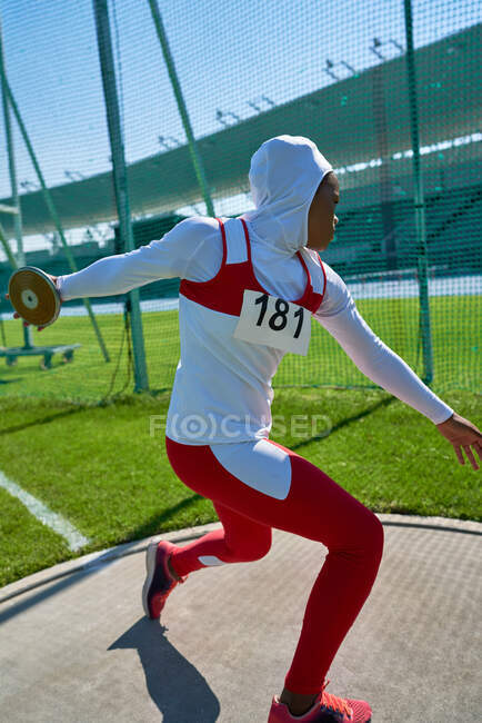 Atleta femminile di atletica leggera in hijab che lancia il disco — Foto stock