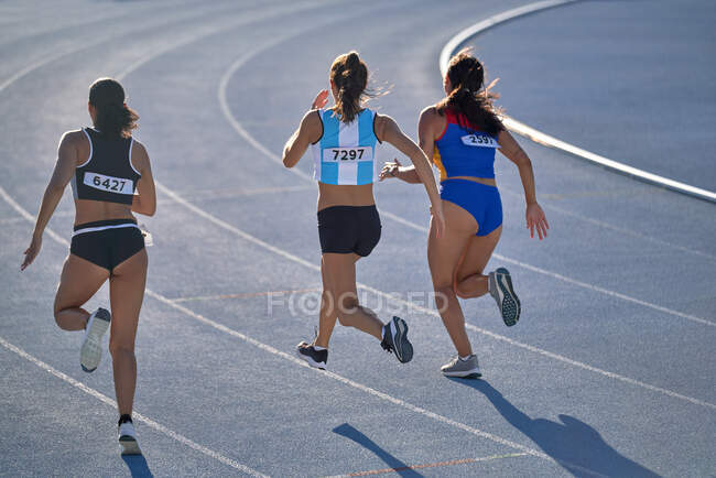 Leichtathletinnen laufen im Wettkampf auf blauer Bahn — Stockfoto