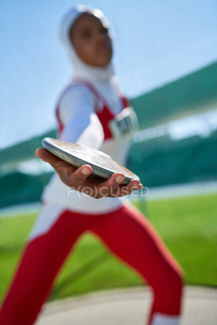 Fechar a pista feminina e atleta de campo no hijab jogando disco — Fotografia de Stock