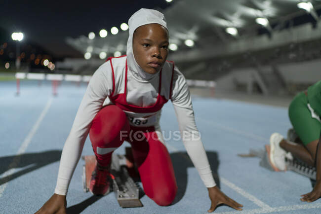 Fokussierte Leichtathletin im Hidschab am Startblock — Stockfoto