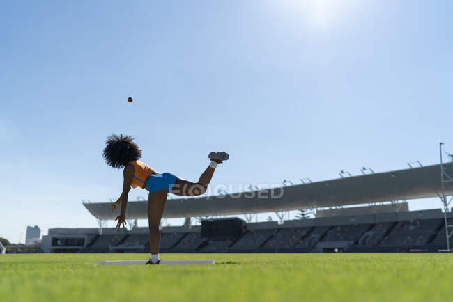 Pista femminile e atleta campo tiro colpo messo in stadio soleggiato — Foto stock