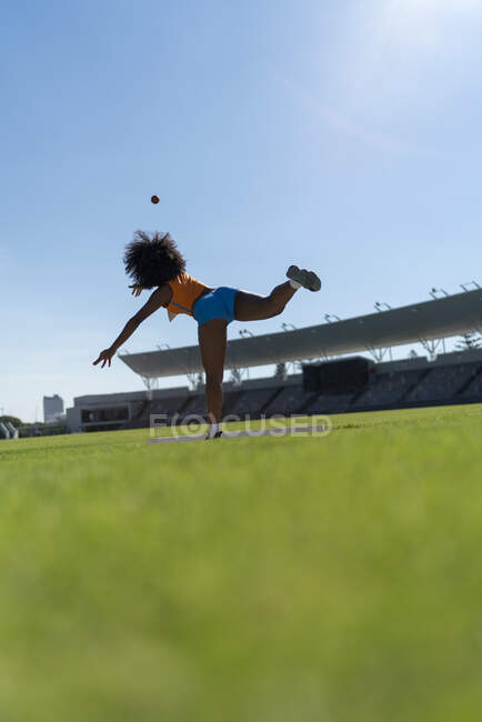 Feminino pista e campo atleta arremesso tiro colocado no estádio ensolarado — Fotografia de Stock