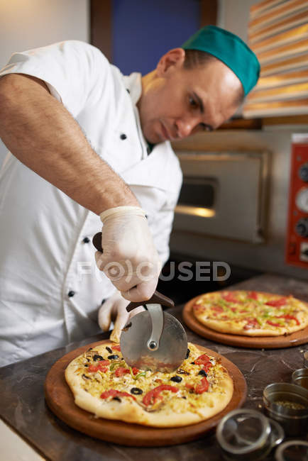 Chef corta pizza preparada na hora — Fotografia de Stock