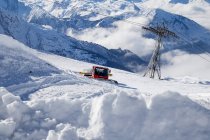 Snowcat machine clearing slope in ski resort area — Stock Photo