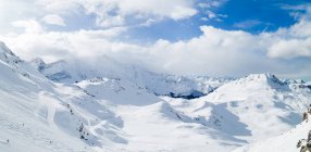 Daytime panoramic view of skiers on snowy mountain slopes — Stock Photo