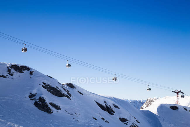 Daytime view of cable cars over snowy mountains — Stock Photo