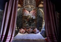 Morocco, Marrakesh, La sultana Marrakech hotel. Bed with pillows and painting — Stock Photo