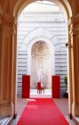 Milan, Salone del Mobile, Fuori Salone. White female statue in niche by red chair and carpet — Stock Photo
