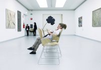 3 de mayo de 2011. Milán, Museo del Novecento. Mujer sentada en la galería - foto de stock