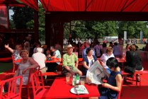 July 24, 2010. London, Hyde Park, People sitting in red Serpentine gallery pavilion by Jean Nouvel — Stock Photo