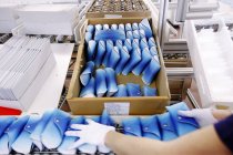 Cropped view of person arranging glasses cases on Luxottica factory line, Sedico, Belluno, Italy — Stock Photo