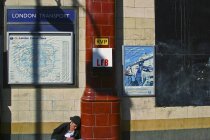 September 14, 2004. England, London, Camden district. Homeless man with can sitting by building wall — Stock Photo