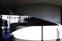 Vista diurna de pessoas silhueta, reflexão e sombra em um prédio de escritórios em Milão — Fotografia de Stock