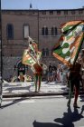 15 de agosto de 2017. Italia, Siena, Palio. Niños llevando banderas en desfile tradicional - foto de stock