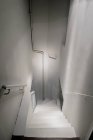 Высокий угол обзора белых лестниц в помещении — стоковое фото