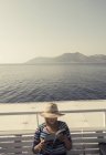 26. Juli 2017. griechenland, skopelitis boat. Freigeschnittenes Porträt einer Frau, die Buch auf Bank eines Segelschiffs liest — Stockfoto