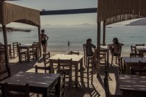 28 de julho de 2017. Grécia. Retrato traseiro de mulheres no café à beira-mar — Fotografia de Stock