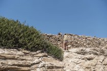 August 2, 2017. Greece, Paros. Portrait of woman petting donkey near wall — Stock Photo