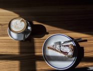 Draufsicht auf Obstkuchen mit Puderzucker und Kaffee auf Holzoberfläche — Stockfoto