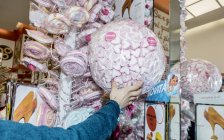 13. april 2017. italien, milan. abgeschnittene Ansicht von Hand greifenden Süßigkeiten und Bonbons in Süßwarengeschäft — Stockfoto