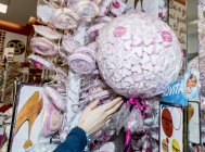 April 13, 2017. Italy, Milan. Cropped view of hand reaching sweets and candies in confectionery store — Stock Photo