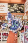 13 de abril de 2017. Itália, Milão. Homem carregando montão de doces na loja — Fotografia de Stock
