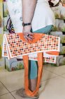 Vista lateral cortada da mulher de pé na loja com saco de compras dobrado — Fotografia de Stock