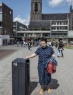 August 8, 2016. Rotterdam. Portrait of woman putting cigarette to garbage bin — Stock Photo