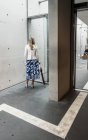 2. august 2016. deutschland, heidelberg. Hinteres Porträt einer Frau mit Regenschirm, die in der Nähe einer Glastür steht — Stockfoto