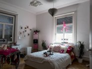 1 de agosto de 2016. Alemania, Konstanz. Vista interior del dormitorio adolescente con gato acostado en la cama - foto de stock