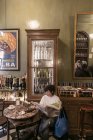 17 de febrero de 2017. Milán, Cafetería da Giacomo. Retrato de la mujer leyendo el periódico en la cafetería - foto de stock