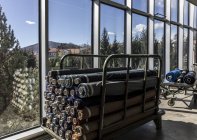 Italie, Valle Mosso, Biella, usine textile. Enrouleurs de tissu sur chariots près des fenêtres — Photo de stock
