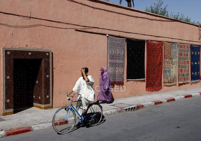 30 сентября 2010 года. Марокко, Марракеш. Велосипедист и женщина на улице — стоковое фото
