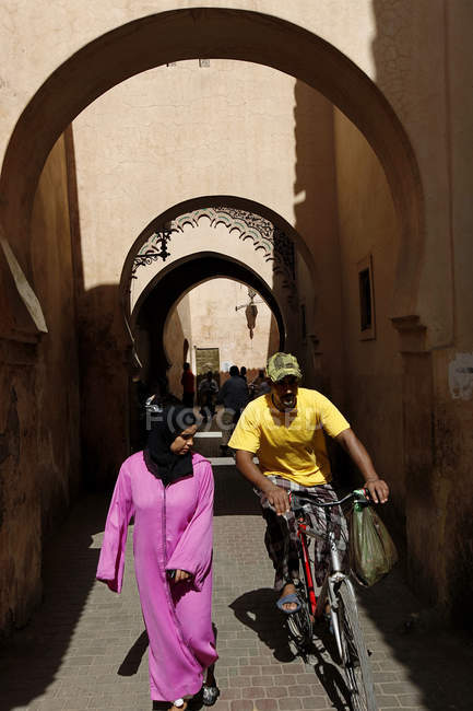 30 de septiembre de 2010. Marruecos, Marrakech. Ciclista superando a mujer en la calle - foto de stock