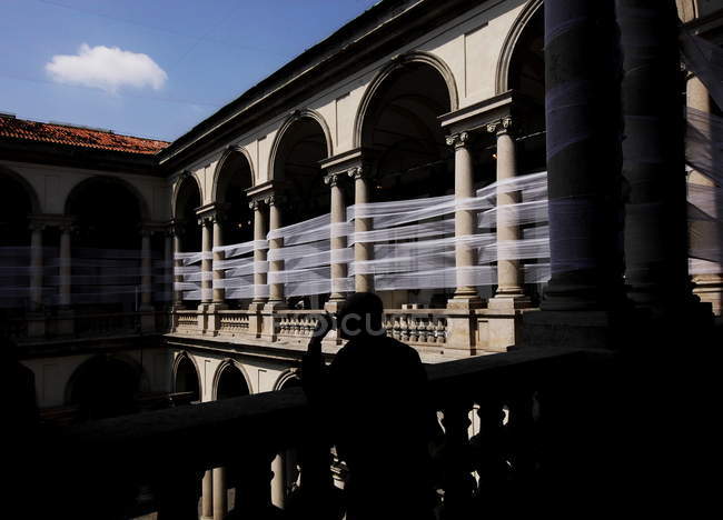 Milán, Palazzo Brera. Silueta de la persona de pie cerca de la barandilla - foto de stock