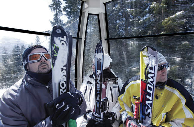 13 марта 2010 года. Италия, Мадонна ди Кампильо. Лыжники в стеклянной гондоле подъемника — стоковое фото