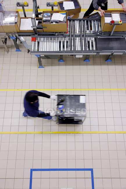 Overhead view of person walking with cart in Luxottica factory, Sedico, Belluno, Italy — Stock Photo