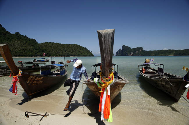 28 de Outubro de 2006. Tailândia, Phi Phi Island, Loh Dalum Bay. Retrato de homem pulando de barco na costa arenosa — Fotografia de Stock