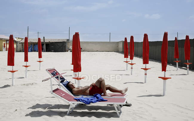12 maggio 2007. Napoli, Marina di Varcaturo. Uomo sdraiato sul letto da spiaggia — Foto stock