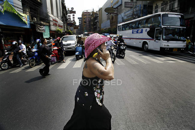 November 8, 2006. Thailand, Bangkok. Woman crossing street and using mobile phone — Stock Photo