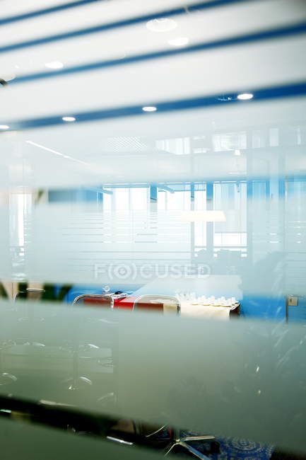 Réflexions intérieures de bureau dans une fenêtre en verre rayé — Photo de stock