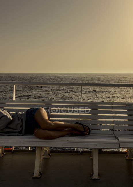 Grécia, barco Skopelitis. Vista cortada de uma mulher deitada no banco — Fotografia de Stock