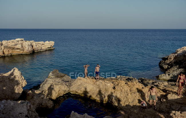 26 de julio de 2017. Grecia, Koufonissi. Retrato de turistas en roca costera - foto de stock