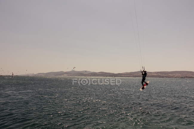 3 de agosto de 2017. Grecia, Paros. Kite surf hombre en frente de la isla de Antiparos - foto de stock