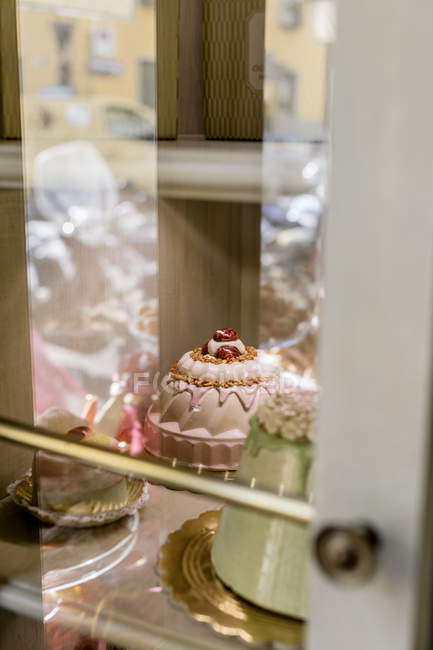 Closeup view of various cakes in glass case in cafe — Stock Photo