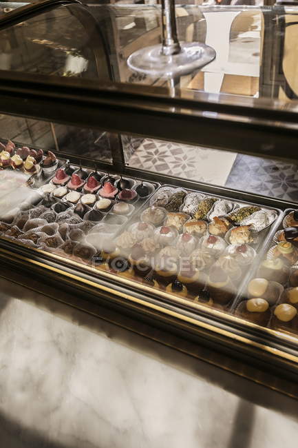 Elevated daytime view of different sweets in cafe glass case — Stock Photo