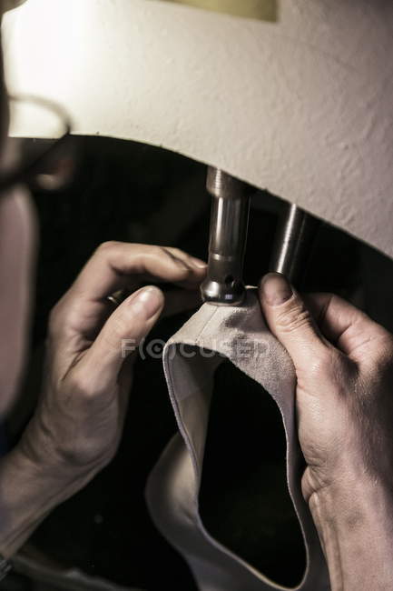 Cropped view of woman sawing shoe detail in machine — Stock Photo